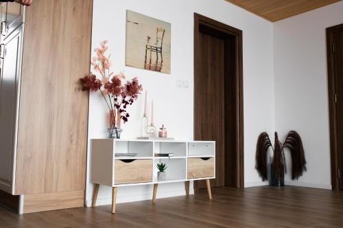 a living room with a white cabinet with flowers on it at Tarvil Apartmani - Zaovine in Bajina Bašta