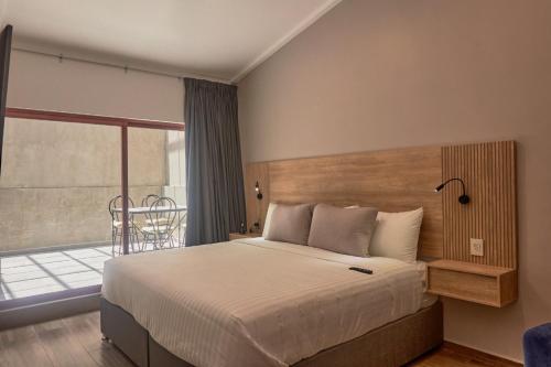 1 dormitorio con 1 cama grande y balcón en Hotel Garcia Peral, en Huajuapan de León