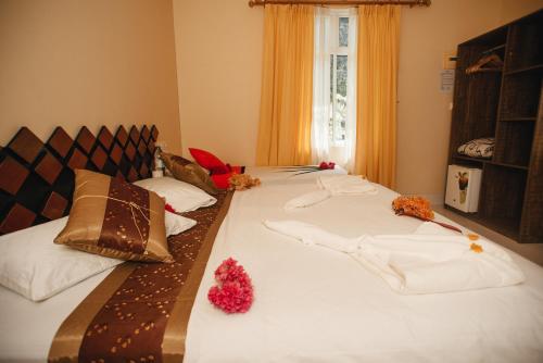 a bedroom with two beds with white sheets and pillows at Summer Vibes Beach Front in Rasdu