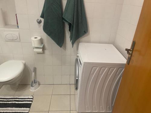 a bathroom with a toilet and a green towel at Zentrale Appartement in Düsseldorf