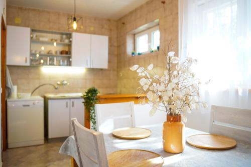 a kitchen with a table with a vase of flowers on it at Villa Blatina in Gradac