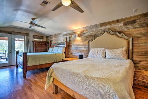 een slaapkamer met 2 bedden en een plafondventilator bij Waterfront Guadalupe River Lodge Home with Dock! in Seguin