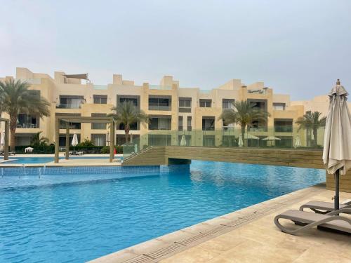- une piscine avec un parasol en face de l'hôtel dans l'établissement Mangrove m3-1b-02, à Hurghada