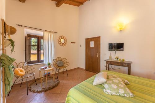 um quarto com uma cama, uma mesa e cadeiras em Agriturismo Cappellese em Castelnuovo della Misericordia