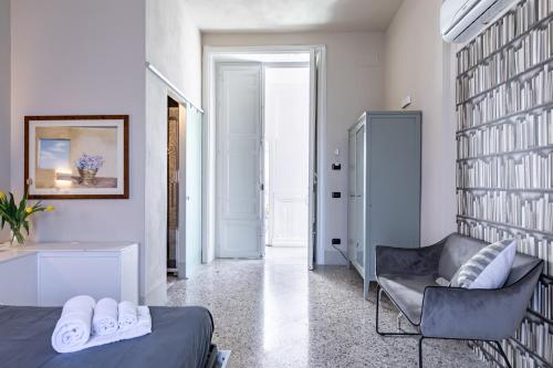 sypialnia z łóżkiem, krzesłem i półką na książki w obiekcie Palazzo Cavarretta - Pinella's Rooms and Apartment w mieście Palermo