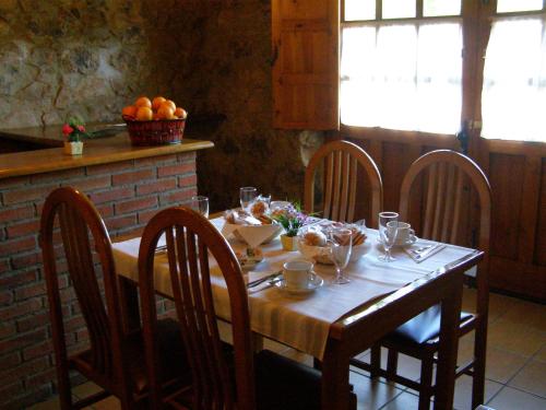 a wooden table with chairs and a table with fruit on it at CASA ALDEA LOS CASTAÑOS in Triongo