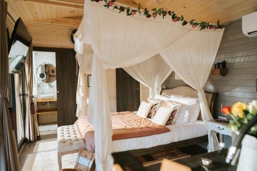 une chambre avec un lit à baldaquin dans l'établissement Berry Séjours, à Malicornay