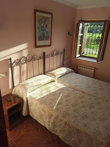 a bedroom with a large bed and a window at CASA ALDEA LOS CASTAÑOS in Triongo