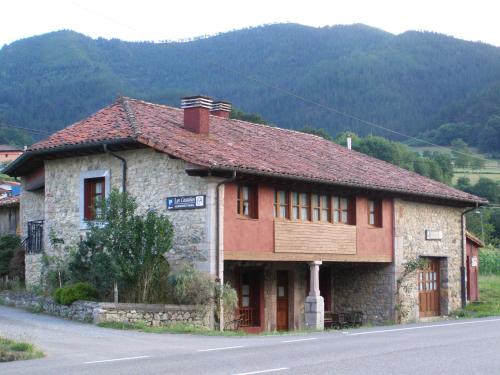 um edifício ao lado de uma estrada com uma montanha em CASA ALDEA LOS CASTAÑOS em Triongo