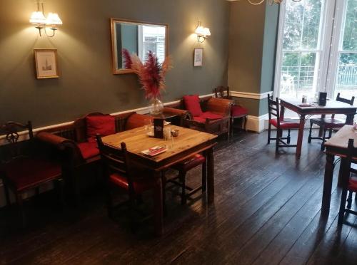 a dining room with a table and chairs in a restaurant at The Priory Hotel in Louth