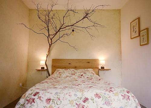 - une chambre avec un lit et un arbre sur le mur dans l'établissement La ferme du Chant de Cailloux, à Die