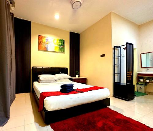 - une chambre avec un grand lit et un tapis rouge dans l'établissement Pemandangan Indah Guest House - Look Out Point Villa-, à Pantai Cenang