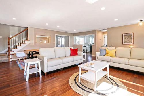 a living room with two white couches and a table at The VIBE House with POOL in Virginia Beach