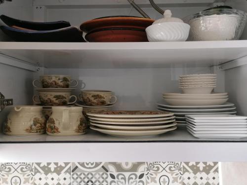 a shelf filled with plates and cups and dishes at Appartement Essaouira Mogador in Essaouira