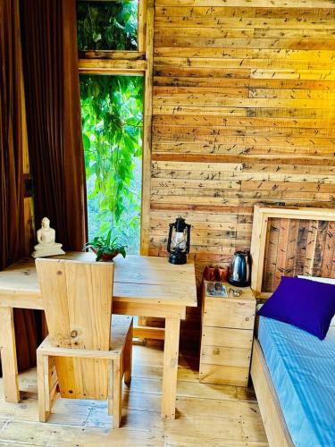 Habitación de madera con mesa y cama en Winwood Ella, en Ella