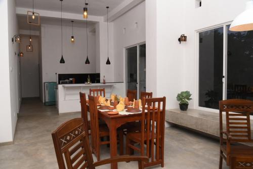 a dining room with a wooden table and chairs at Everdew Kandy in Kandy