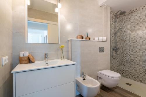 bagno con lavandino, servizi igienici e specchio di Villa Mercuri a Alcudia