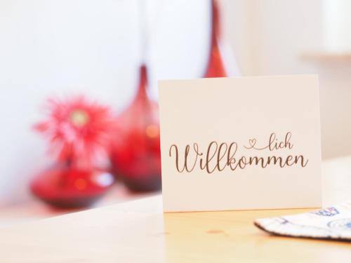 un panneau sur une table avec quelques vases rouges dans l'établissement Ferienwohnung "Sonnenblick", à Ahlbeck