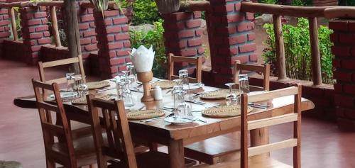 a wooden table with plates and silverware on it at Karatu safari camp Lodge in Karatu