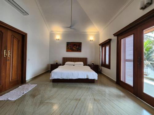 a large bedroom with a bed and a large window at Villa 17 Luisa by the Sea in Madgaon