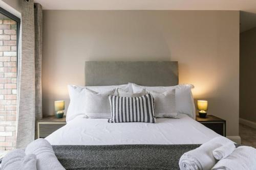 a bedroom with a large white bed with two lamps at Three The Stables at Corrstown Village in Portrush