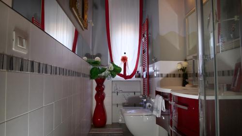 ein Badezimmer mit einer roten Vase mit einer Blume in der Unterkunft Квартира люкс в Милане (Appartamento di lusso a Milano) in Sesto San Giovanni