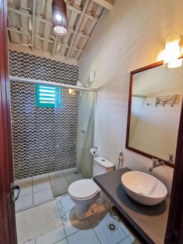 a bathroom with a toilet and a sink and a shower at La Villa Tropicale linda casa pertinho do mar ! in Icaraí