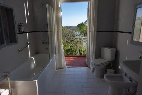 ein Bad mit einer Badewanne, einem WC und einem Fenster in der Unterkunft Pristine Residence Iguazú in Puerto Libertad