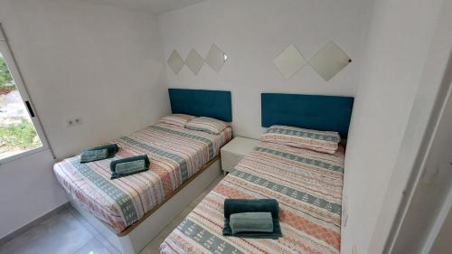duas camas num pequeno quarto com duas cadeiras em Ibi Apartamentos la Cantera Peñíscola em Peníscola