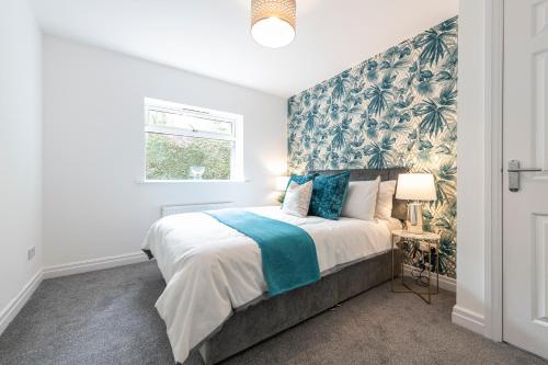 een slaapkamer met een groot bed met blauw en groen behang bij The Croft by Nordstay in Steeton