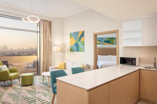a hotel suite with a kitchen and a living room at Holiday Inn & Suites - Dubai Science Park by IHG in Dubai