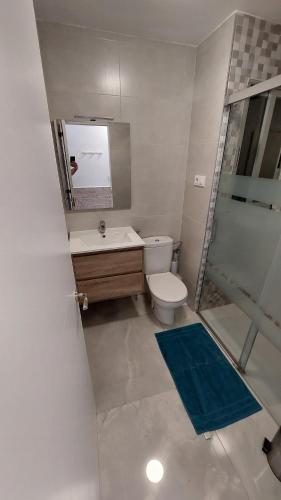 uma casa de banho com um WC, um lavatório e um espelho. em Ibi Apartamentos la Cantera Peñíscola em Peníscola