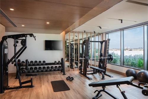 a gym with cardio equipment and a large window at Holiday Inn & Suites - Dubai Science Park by IHG in Dubai
