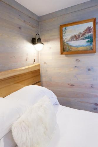a bedroom with a white bed with a picture on the wall at Asheville River Cabins in Arden