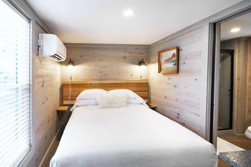 a bedroom with two beds in a room with wooden walls at Asheville River Cabins in Arden