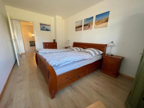 Schlafzimmer mit einem großen Holzbett in der Unterkunft Charmante Ferienwohnung in idyllischer Lage in Jever