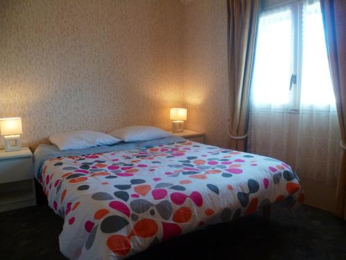 a bedroom with a bed with a flowered comforter and a window at Maison de 2 chambres avec piscine partagee jardin amenage et wifi a Saint Genies a 8 km de la plage in Saint-Geniès