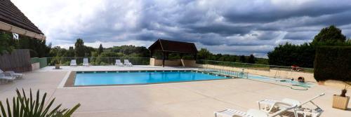 une grande piscine avec des chaises et un gazebo dans l'établissement Maison confortable avec piscine partagée à Saint-Genies., à Saint-Geniès