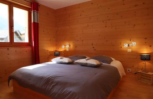 ein Schlafzimmer mit einem Bett mit zwei Kissen darauf in der Unterkunft Petit nid douillet au coeur de SalvanLes Marécottes in Salvan