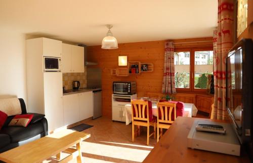 a kitchen and living room with a table and chairs at Petit nid douillet au coeur de SalvanLes Marécottes in Salvan