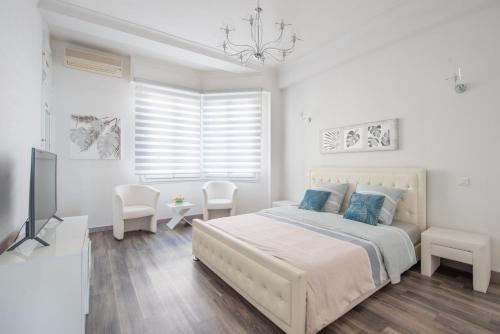 une chambre blanche avec un lit et une télévision dans l'établissement SEA FRONT SUITE - Panoramic View with Terrace - 85 m, à Nice