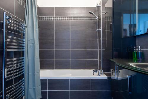 une salle de bain avec une baignoire et un lavabo dans l'établissement SEA FRONT SUITE - Panoramic View with Terrace - 85 m, à Nice