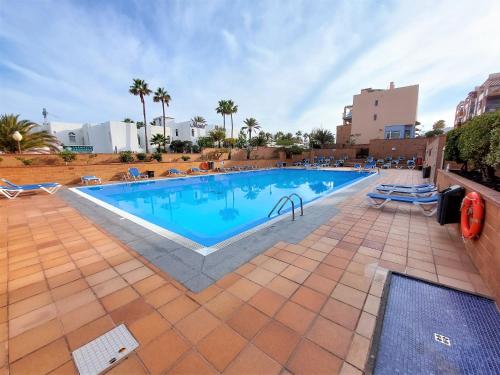 una piscina en un complejo con palmeras en Casa El Secreto, en Playa de Jandía