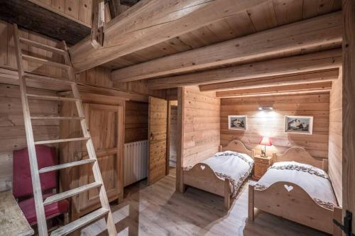 Habitación de madera con 2 camas y escalera en Chalet ferme Laiterie, en Peisey-Nancroix