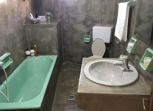 a bathroom with a sink and a toilet and a tub at Mikio House in Kalabaka