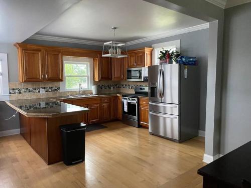 a kitchen with wooden cabinets and a stainless steel refrigerator at 3bed 2bath nestled in cozy Grandview neighborhood in Dubuque
