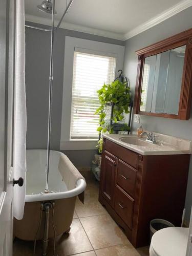 a bathroom with a tub and a sink and a bath tub at 3bed 2bath nestled in cozy Grandview neighborhood in Dubuque
