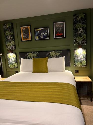 a bedroom with a large bed with green walls at The Baltic Hotel in Liverpool