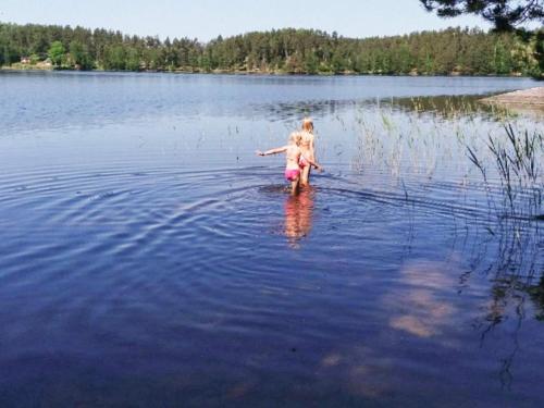 a little girl walking in the water on a lake at 5 person holiday home in GAMLEBY-By Traum in Gamleby