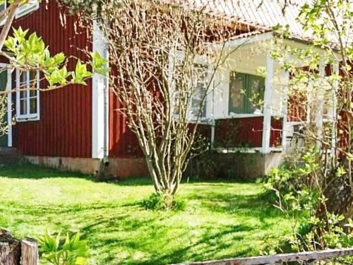 a red house with a small tree in the yard at 5 person holiday home in GAMLEBY-By Traum in Gamleby